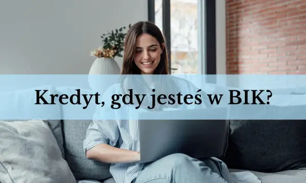 Uśmiechnięta kobieta z laptopem na kanapie.